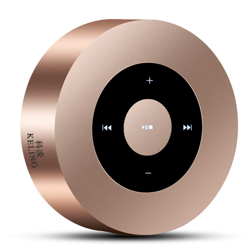Rose gold round portable Bluetooth speaker with central black control panel featuring playback and volume buttons