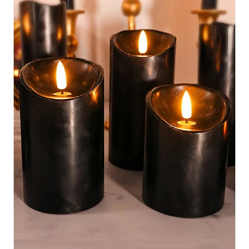 Group of black LED pillar candles with glowing yellow flame tips on a white surface.