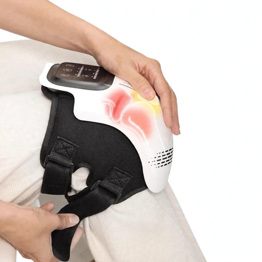 White and black electric knee massager strapped onto a person's knee, featuring a digital control panel and glowing printed