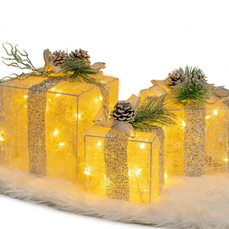 Three illuminated tinsel gift box decorations with pinecones and bows.