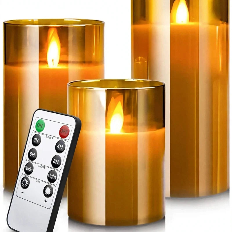 Three gold glass flameless pillar candles with glowing LED flames and a remote control.