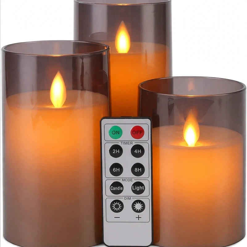 Three flameless LED pillar candles in translucent brown glass holders with a remote control.