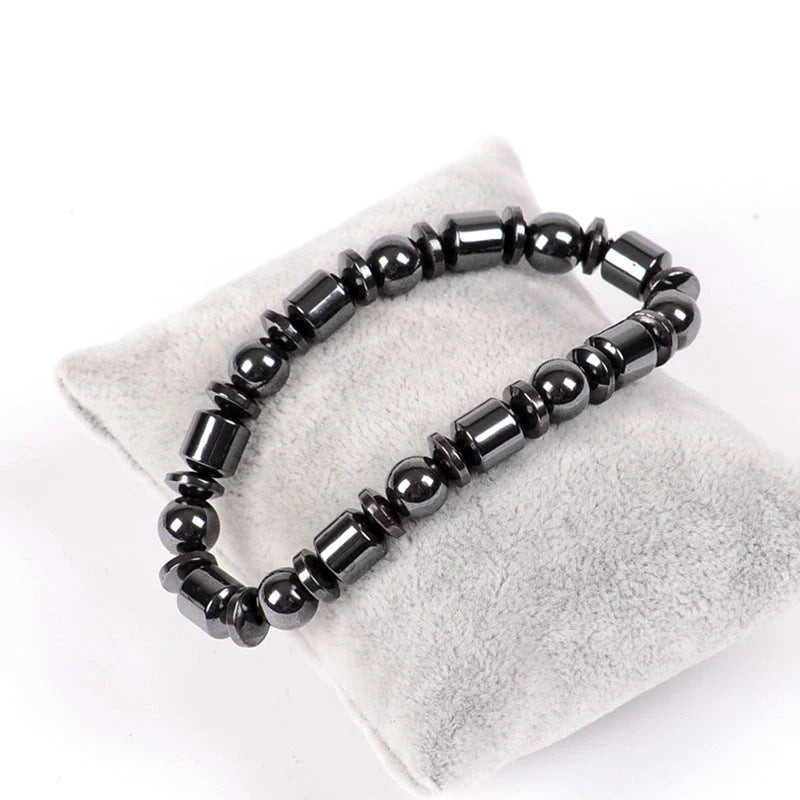 Hematite bead bracelet on a grey display pillow.
