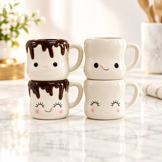 Four stacked ceramic mugs styled like marshmallows with cute faces and chocolate drizzle details.