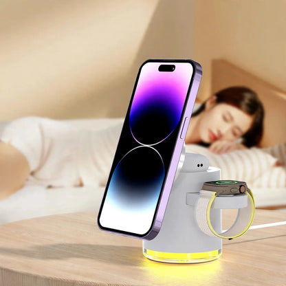 Magnetic wireless charging dock holding a smartphone, smartwatch, and earbuds with a glowing yellow base on a wooden table