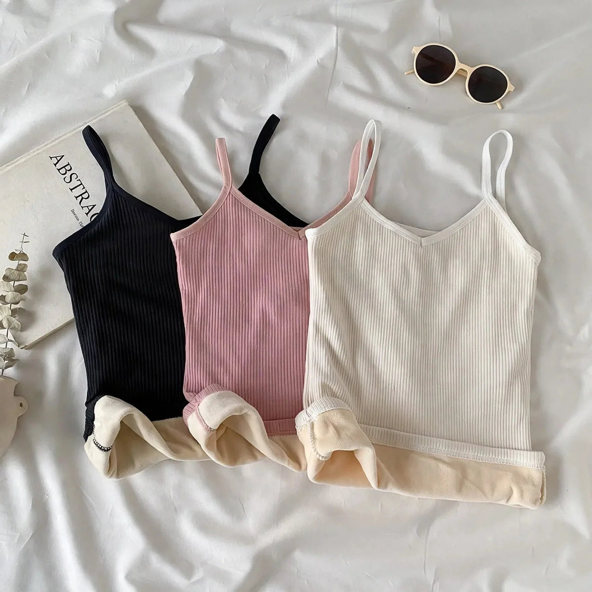 Three ribbed thermal camisoles in black, pink, and white with plush lining.
