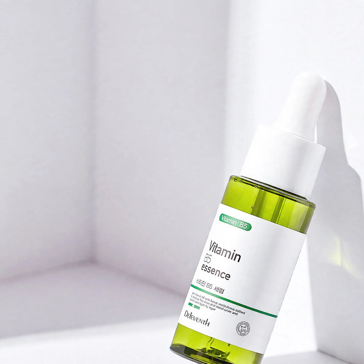 Vitamin B5 essence bottle with a dropper against a white backdrop featuring marketing text.