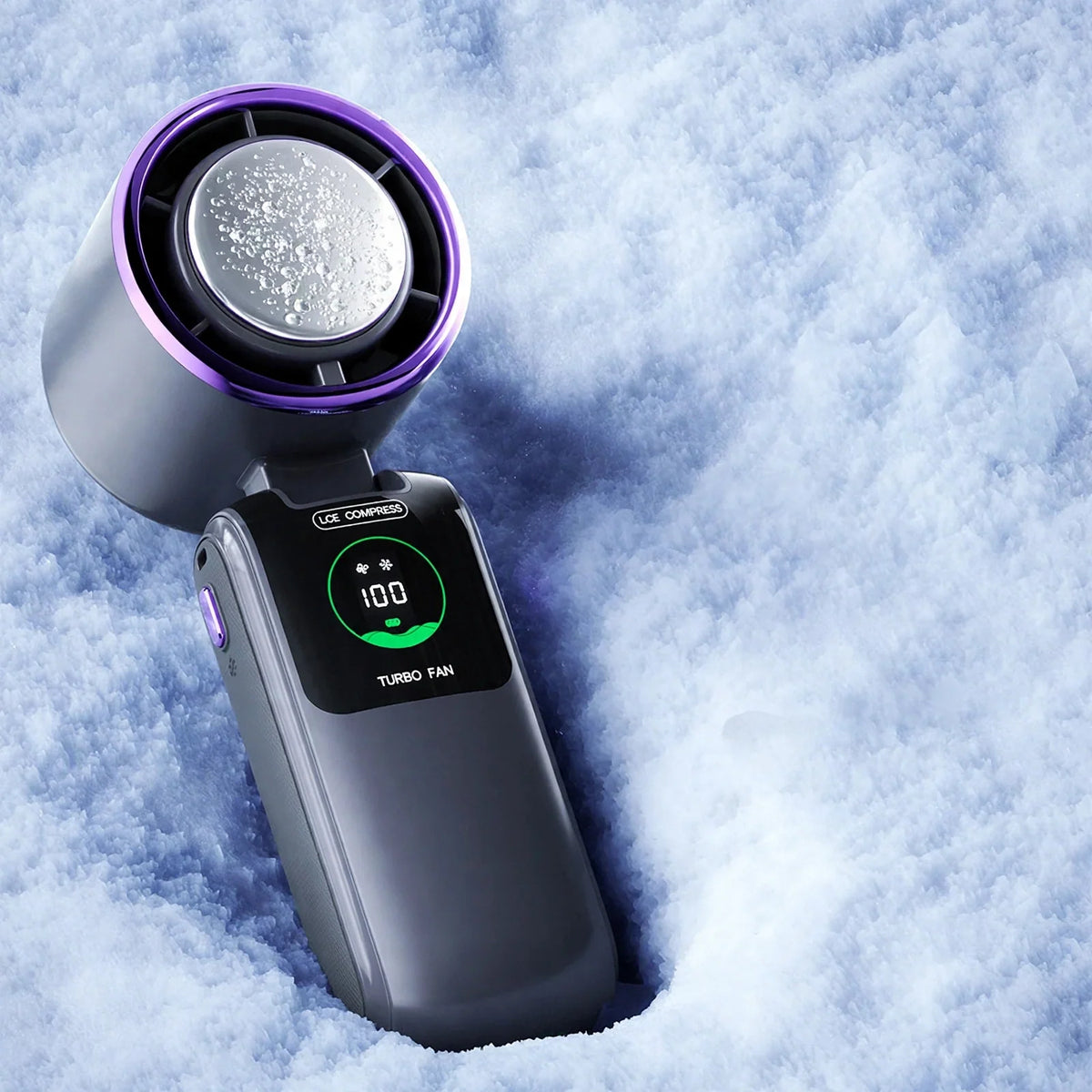 Handheld turbo cooling fan with frosted ice compress plate and digital display, on a snowy background.