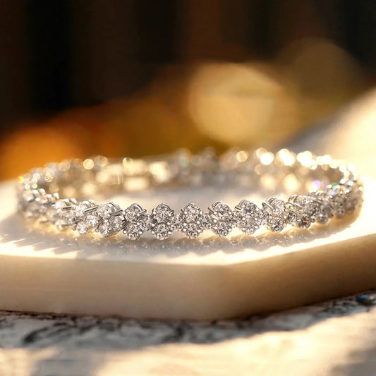 Silver link bracelet set with sparkling round zirconia stones, displayed on a light surface.