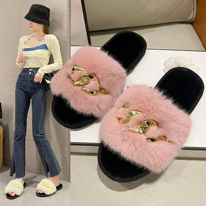 Pink fuzzy mule slippers with black footbeds and chunky gold-tone chain hardware.