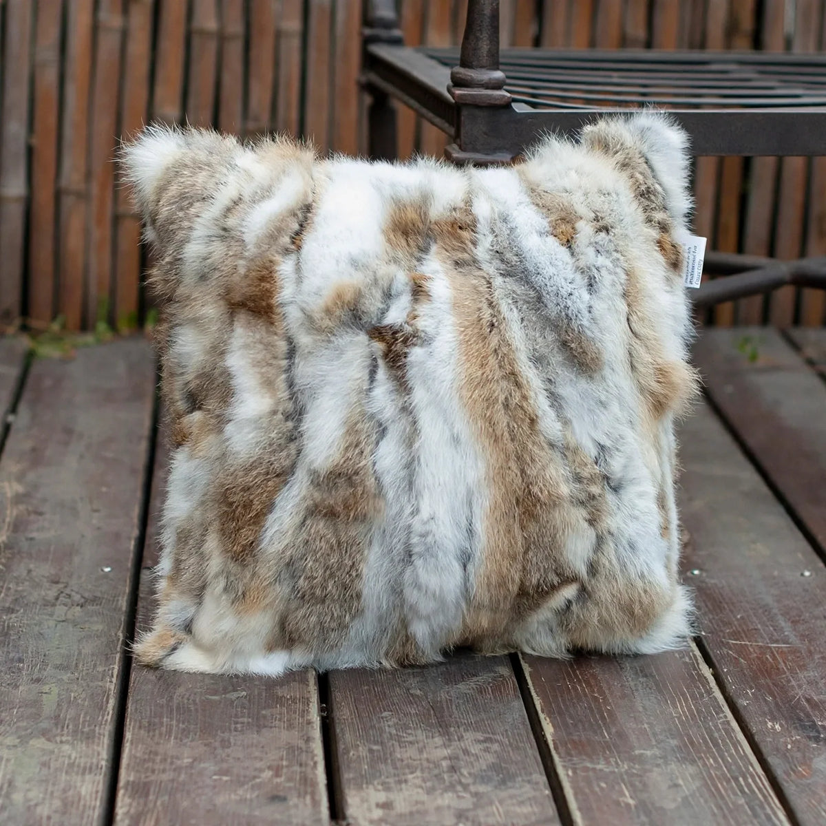 Square patchwork fur pillow cover with brown, white, and gray vertical stripes.
