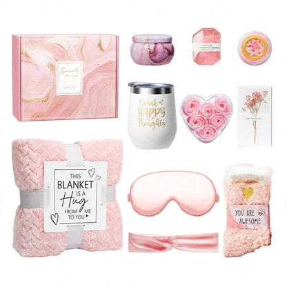 Pink bath gift set with candle, soap, blanket, tumbler, eye mask, socks, and gift box.