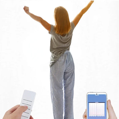 Woman stretching in front of open curtains, with hands holding a remote and smartphone control app.