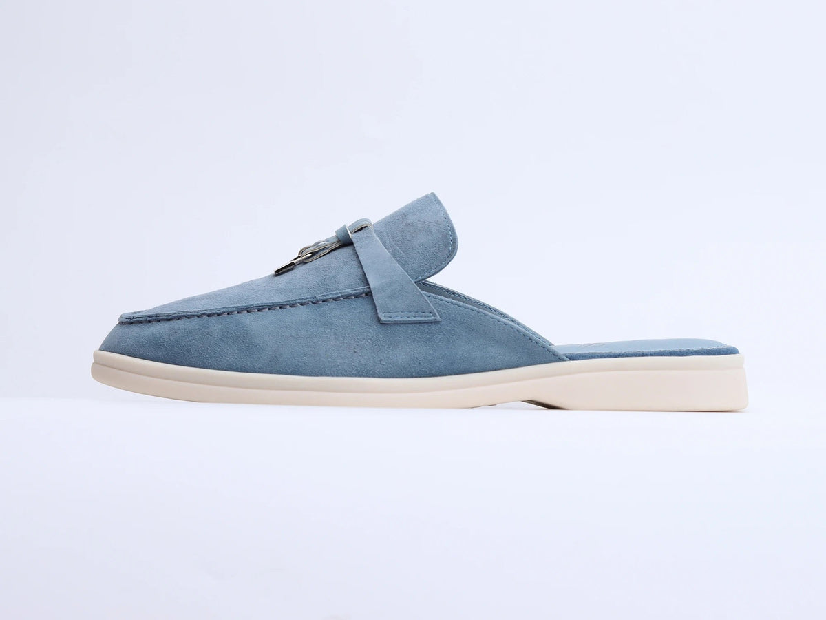 Blue suede mule with white sole side view showing metal ring and tassel detail