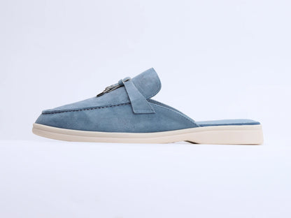 Blue suede mule with white sole side view showing metal ring and tassel detail