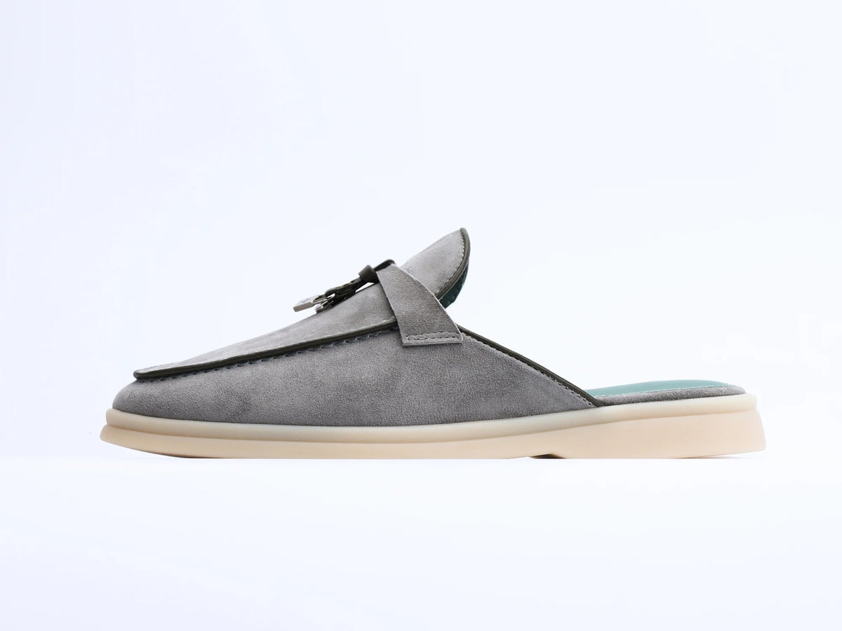 Side view of gray suede mule with tassel and light sole