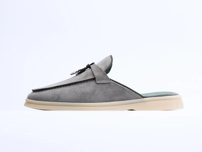 Side view of gray suede mule with tassel and light sole