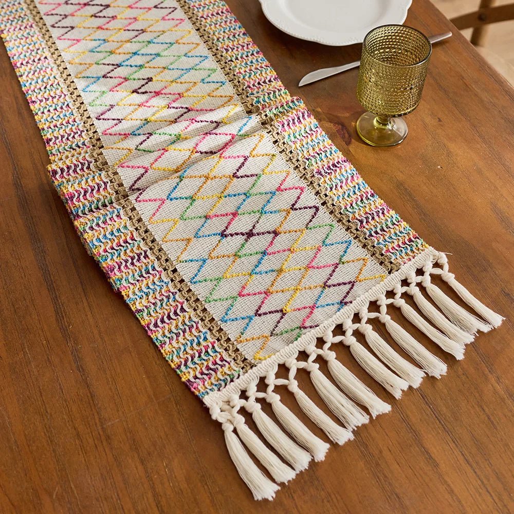 Home decor woven table runner with boho tassels and embroidered pattern on wood dining table