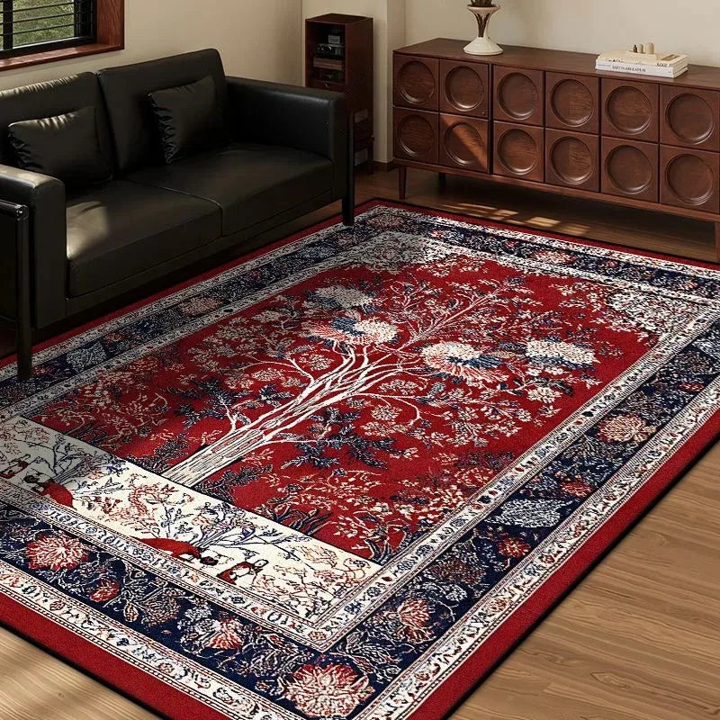 Red vintage area rug with central tree of life motif and ornate floral borders in a living room.