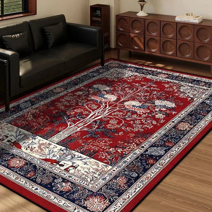 Red vintage area rug with central tree of life motif and ornate floral borders in a living room.