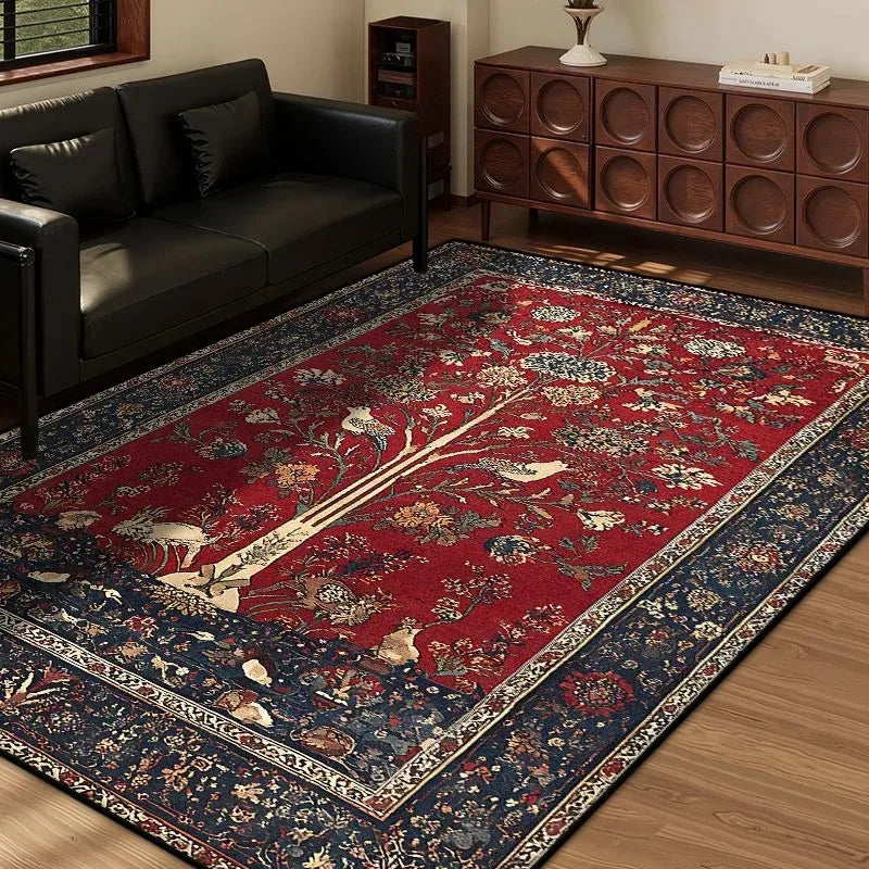 Red and blue vintage area rug featuring a tree motif, displayed in a living room with a black sofa.