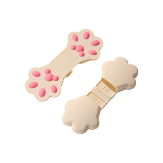 Two beige cat paw finger grip clips with pink silicone toe bean pads.