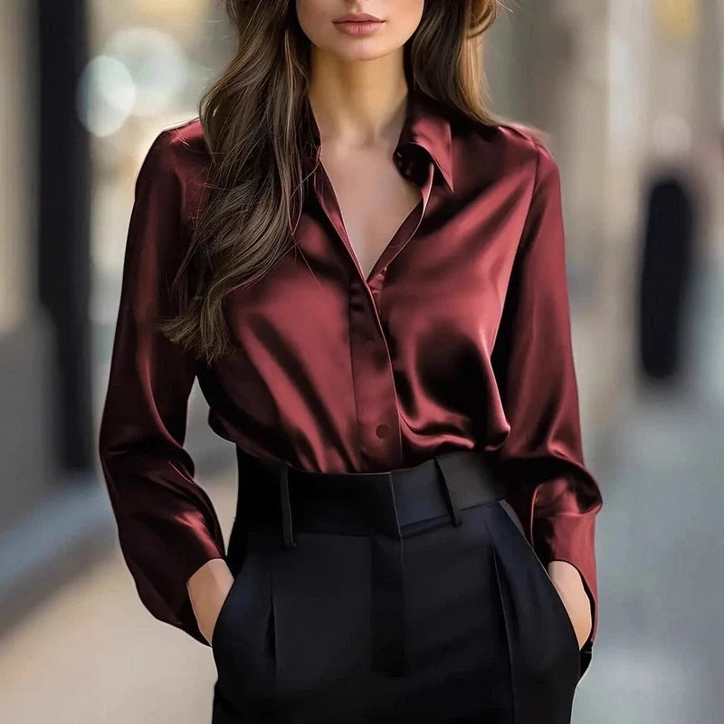 Woman wearing a long-sleeve burgundy button-down shirt and black trousers.