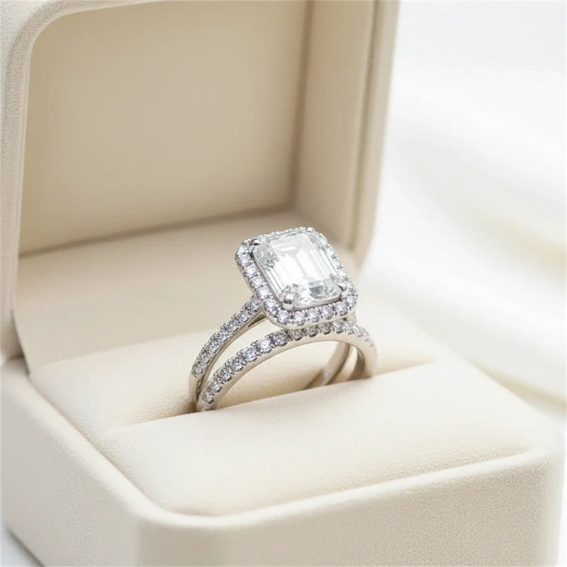 Emerald-cut halo ring and matching pavé band in a velvet ring box.