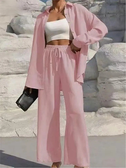 Women's pink lounge set with long sleeve button-up shirt and wide leg pants with a drawstring waist