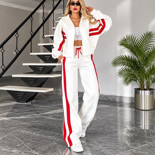 White tracksuit set with red stripes on the zip-up jacket sleeves and matching wide-leg pants.