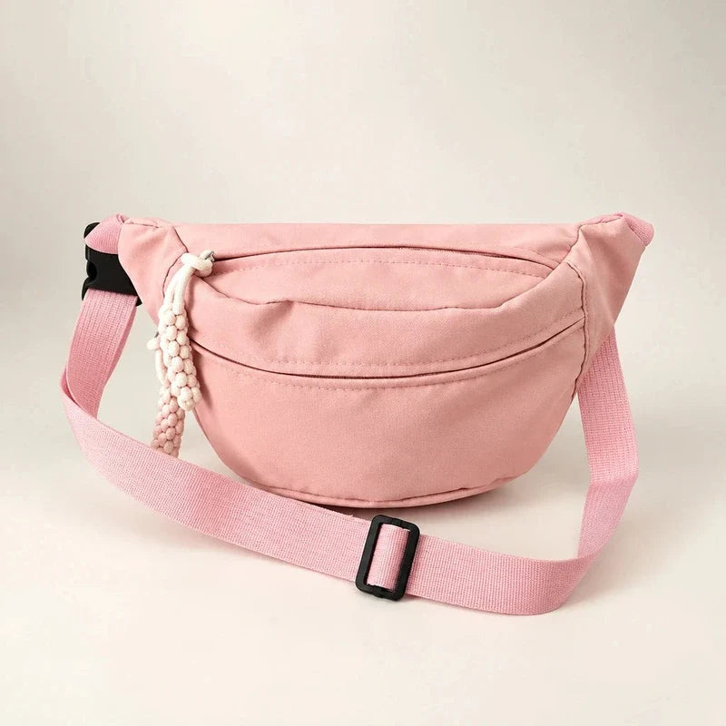 Pink crescent sling bag with an adjustable strap, black buckle, and beaded zipper pull.