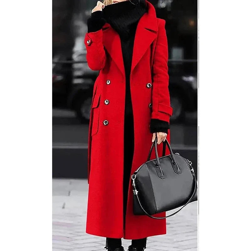 Woman wearing a bright red double-breasted long wool overcoat with black sweater and carrying a black handbag outdoors