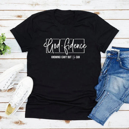 Black t-shirt with white Godfidence text and sneakers and jeans on wood background