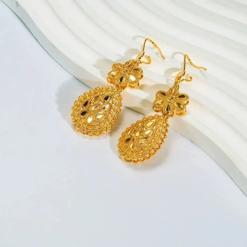 Gold filigree drop earrings featuring a flower top and textured teardrop pendant.