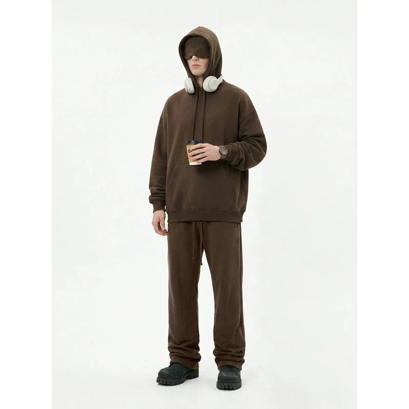 Man wearing a brown fleece hoodie and jogger matching set with an integrated eye mask in the hood