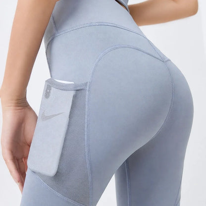 Side view of light blue yoga leggings featuring a mesh side pocket holding a smartphone.