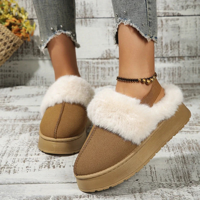 Tan platform slippers with white faux-fur trim worn with cropped distressed jeans.