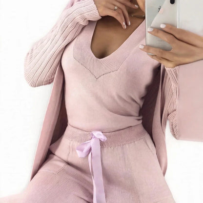 Woman wearing a three-piece pink knit set with a V-neck top, cardigan, and drawstring pants.