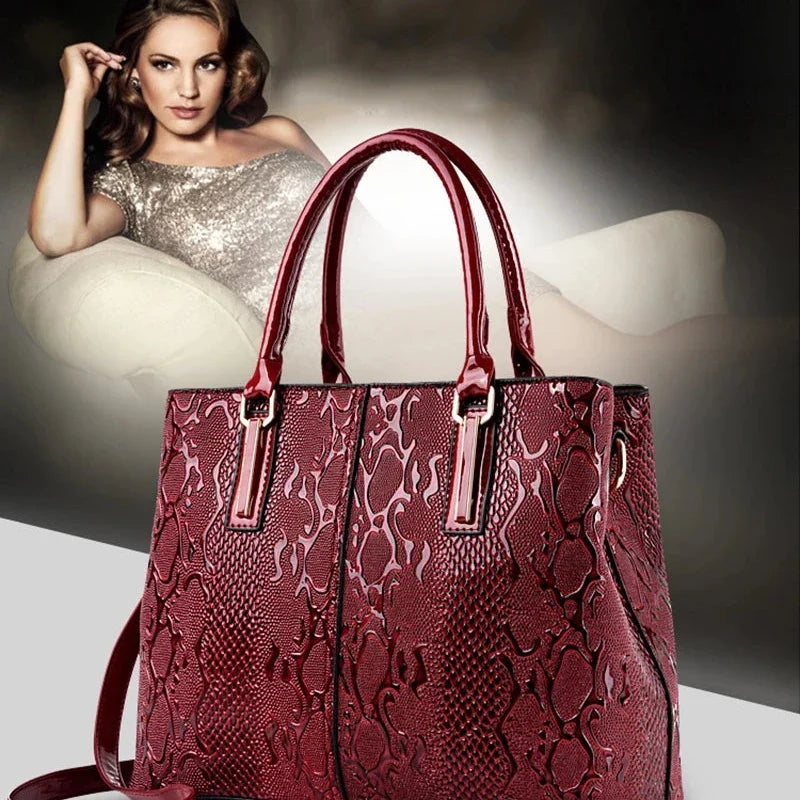 Red textured patent leather tote bag with dual top handles.