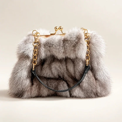 Fluffy gray faux fur evening handbag with a gold kiss lock frame and chain strap.