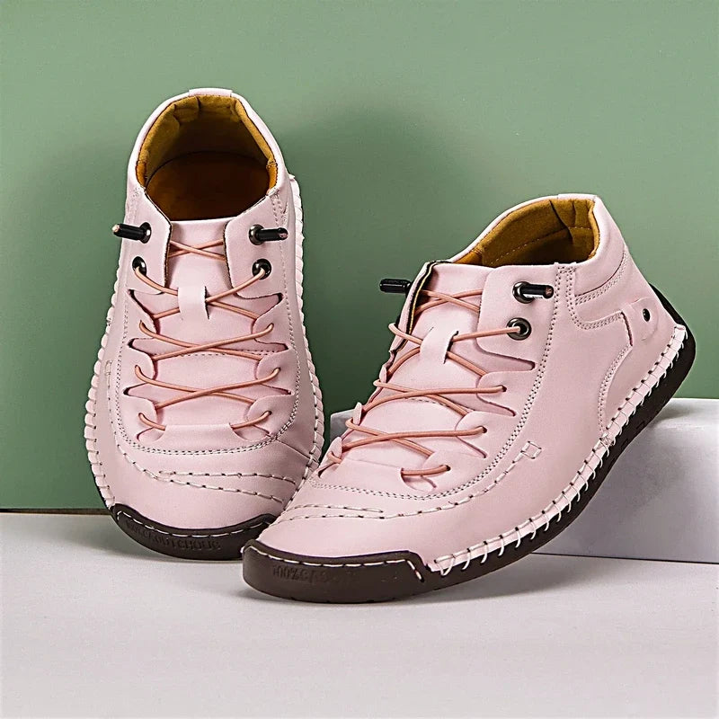 Pink casual shoes with lace-up bungee cords, contrast white stitching, and dark brown soles.