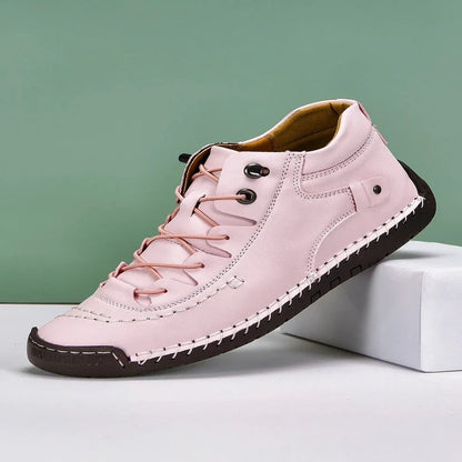 Pink casual leather shoe with white contrast stitching, dark brown sole, and matching laces, displayed on a white block.