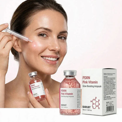 Woman applying pink facial serum with a dropper beside product bottles and packaging
