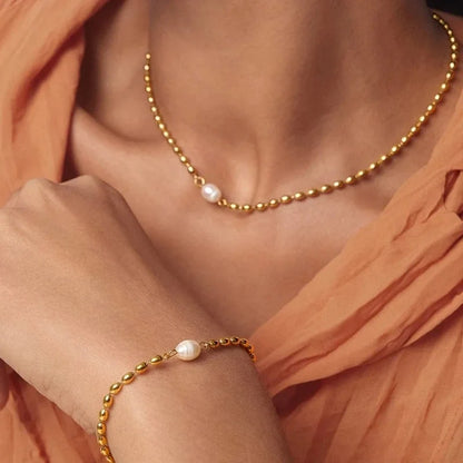 Gold beaded chain necklace and bracelet featuring a single white pearl on each.