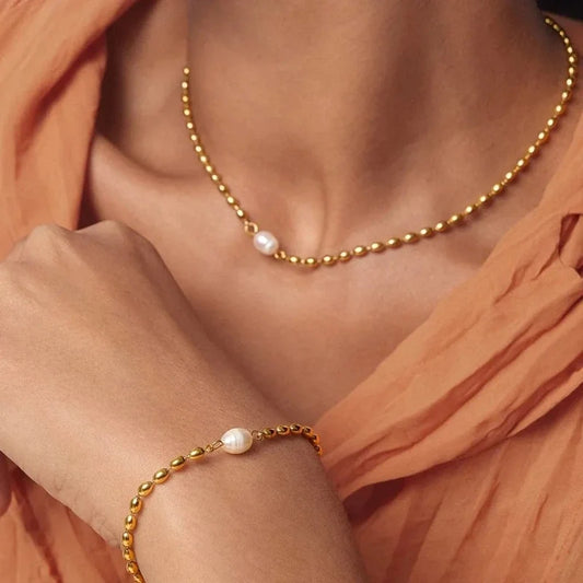 Gold beaded chain necklace and bracelet featuring a single white pearl on each.