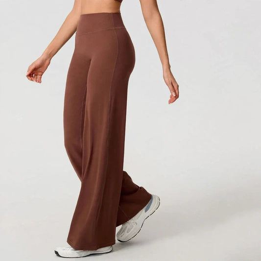 High-waisted brown wide-leg yoga pants worn with white sneakers.