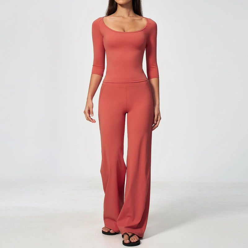 Woman wearing a matching terracotta lounge set with a scoop neck top and wide leg pants.