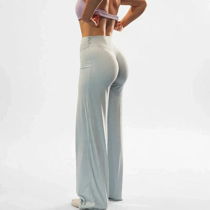 Rear view of person wearing high-waisted light grey wide-leg yoga pants against a plain white background.