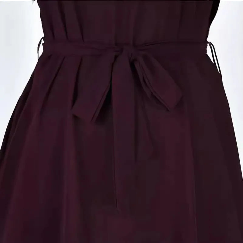 Close-up of the waist of a dark purple sheath dress with a tied fabric belt