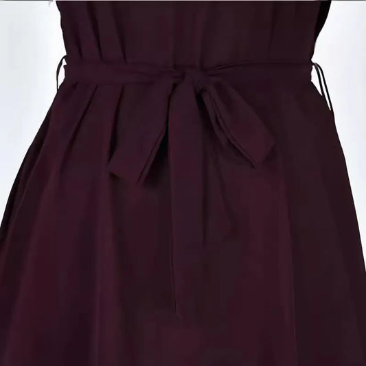 Close-up of the waist of a dark purple dress with a matching tie belt.